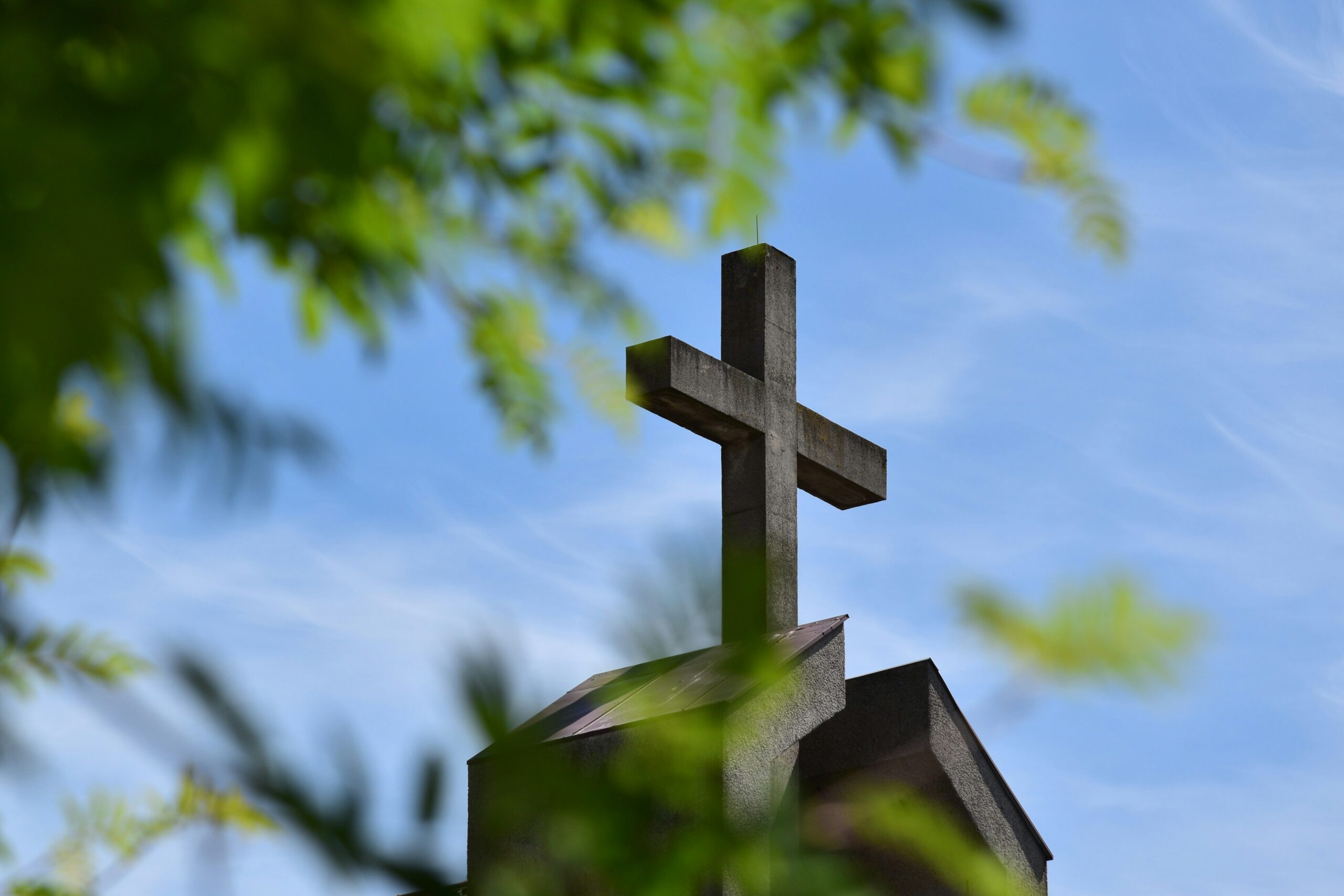 Une croix sur fond de ciel avec de la végétation 